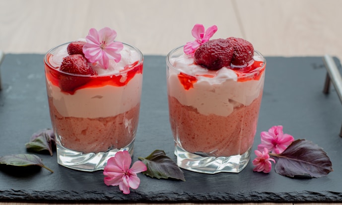 two desserts with raspberries and whipped cream