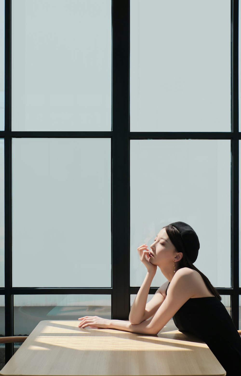 a woman sitting on a table in front of a window
