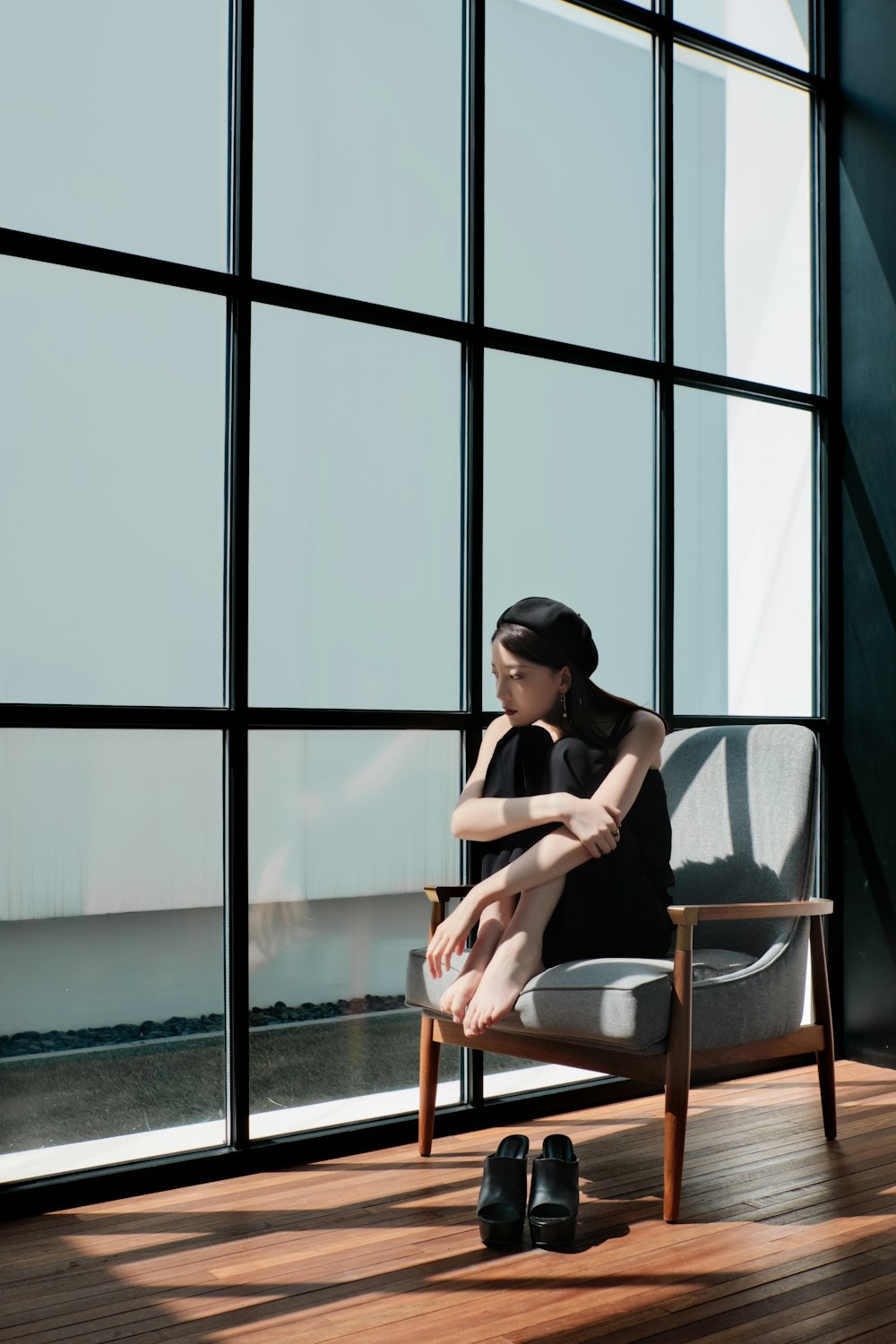 a woman sitting on a chair in front of a window