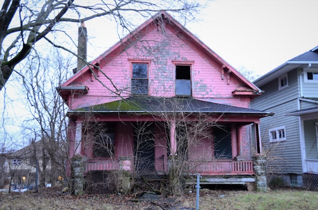 an old pink house with a broken window