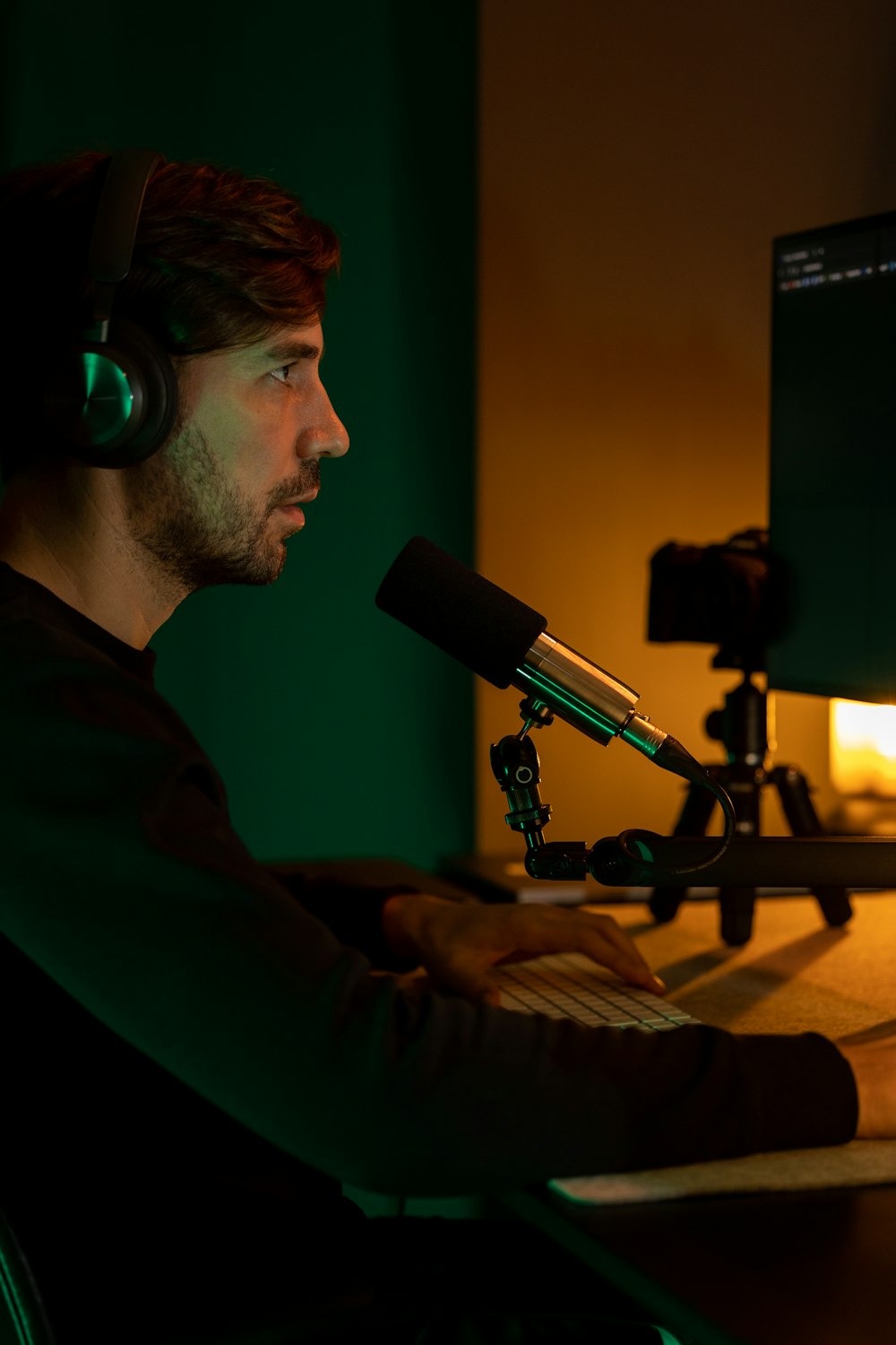 a man sitting in front of a computer with headphones on