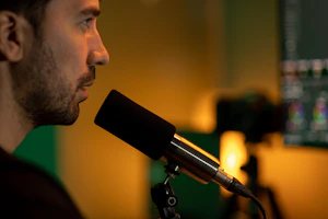 A cheerful freelancer recording a video tutorial in a cozy home studio with professional lighting.