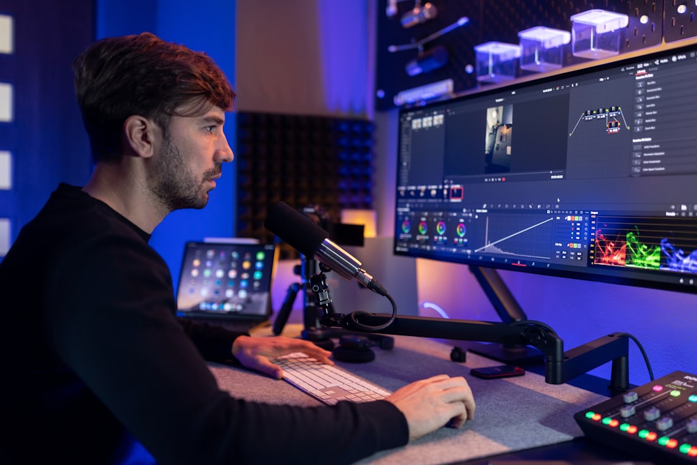 a man sitting in front of a computer monitor