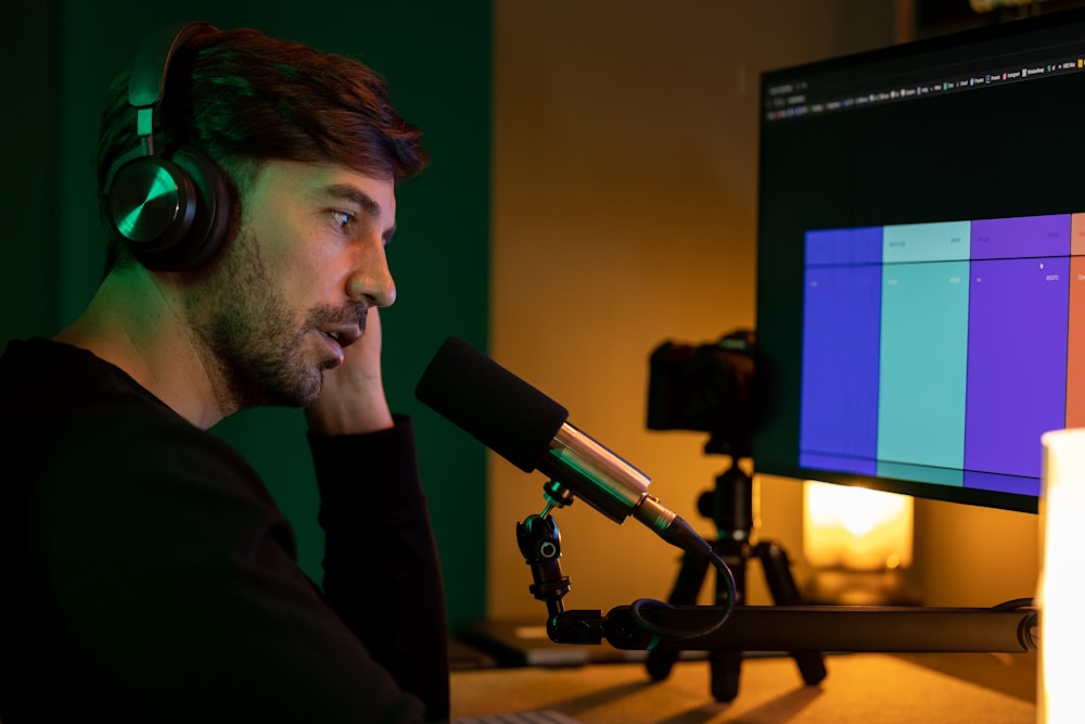 a man sitting in front of a computer with headphones on