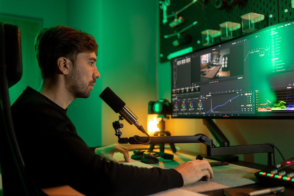 a man sitting at a desk with a microphone