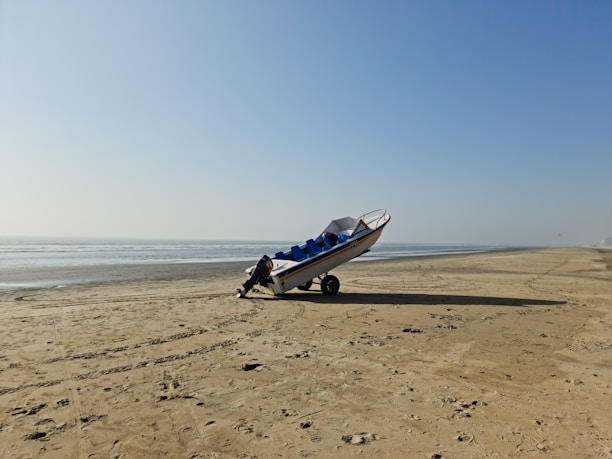 A sleek boat securely fastened on a trailer ready for shipment under a clear blue sky.