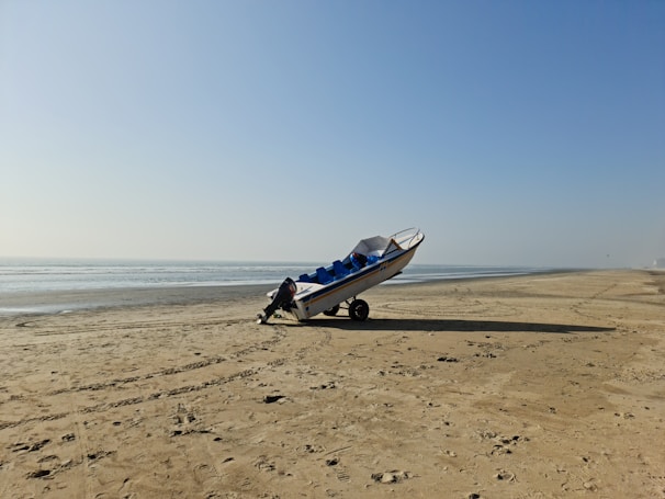 A friendly driver securing a boat on a trailer under a bright blue sky.