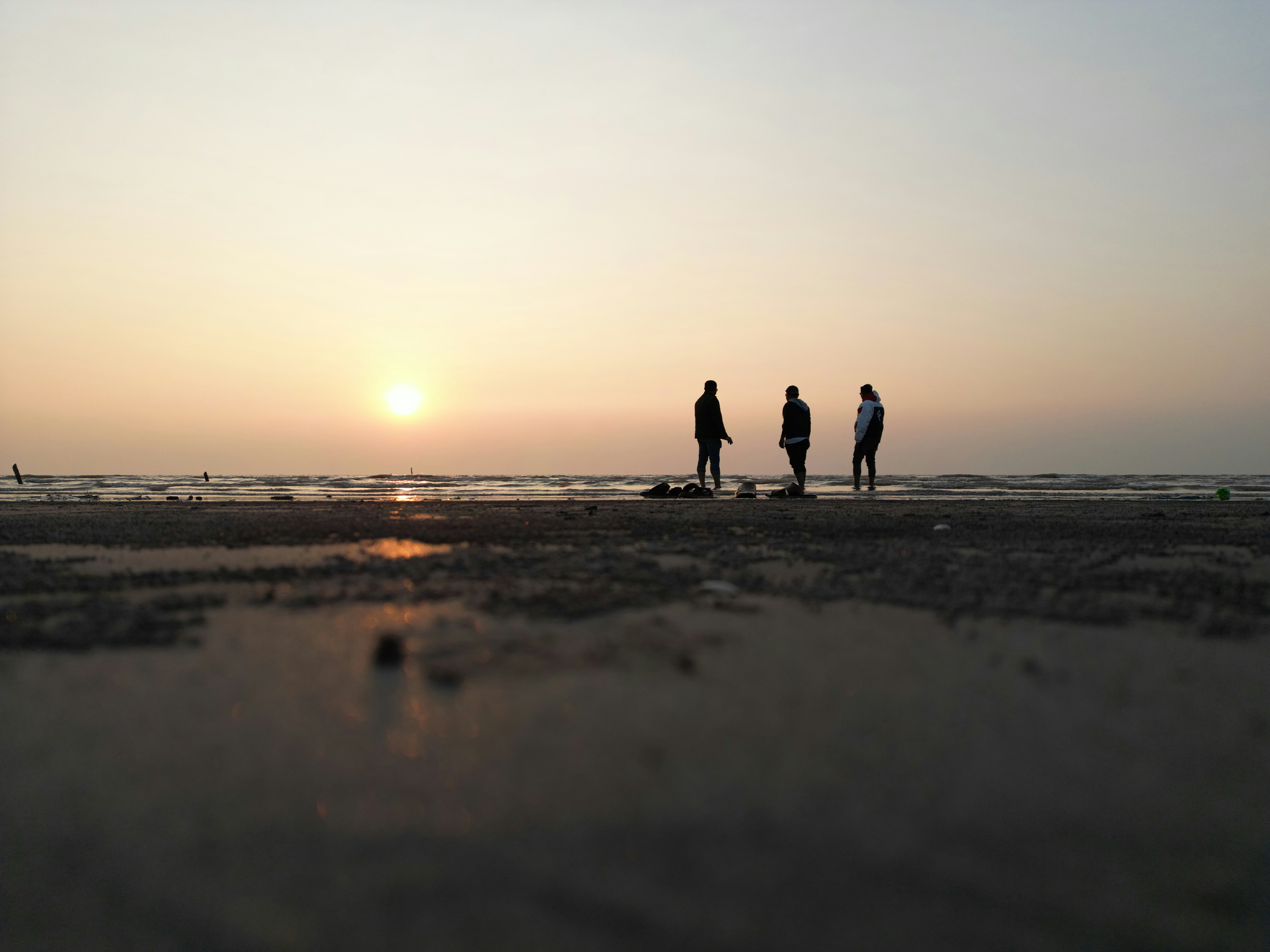 a group of people standing on top of a sandy beach