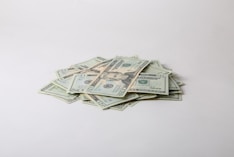 a pile of money sitting on top of a white table