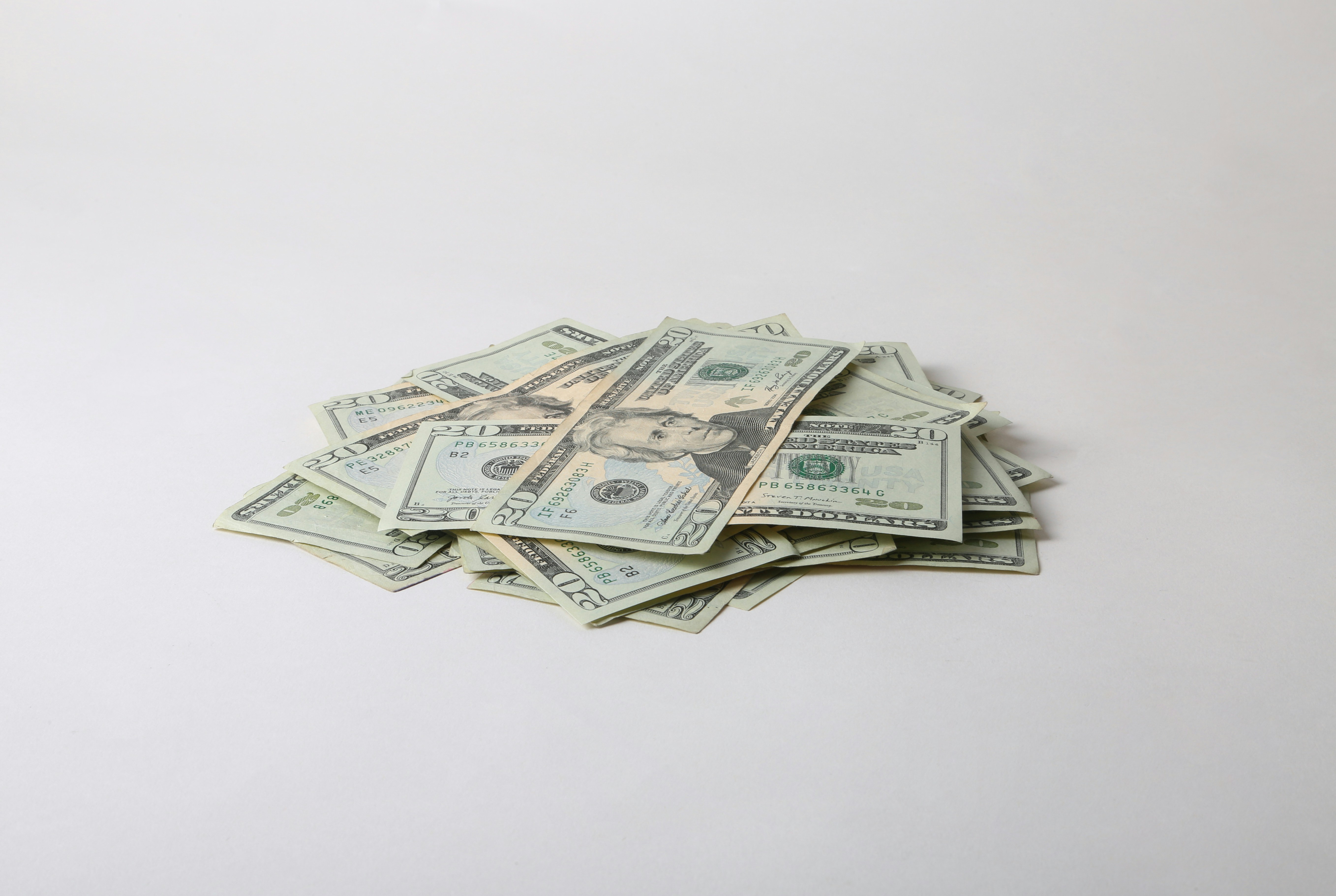 a pile of money sitting on top of a white table