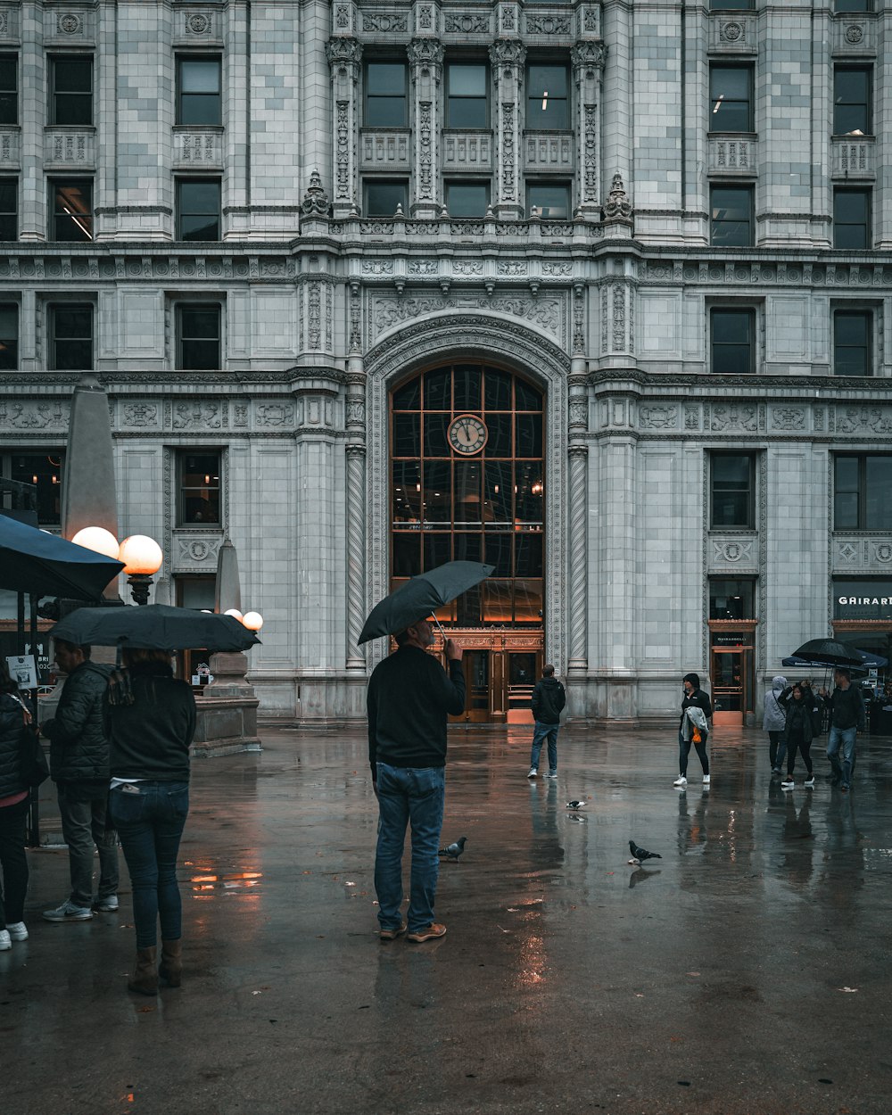 a group of people holding umbrellas in front of a building