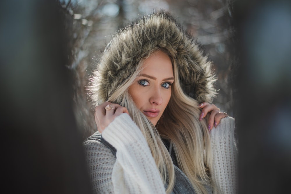 a woman in a hooded jacket looking at the camera