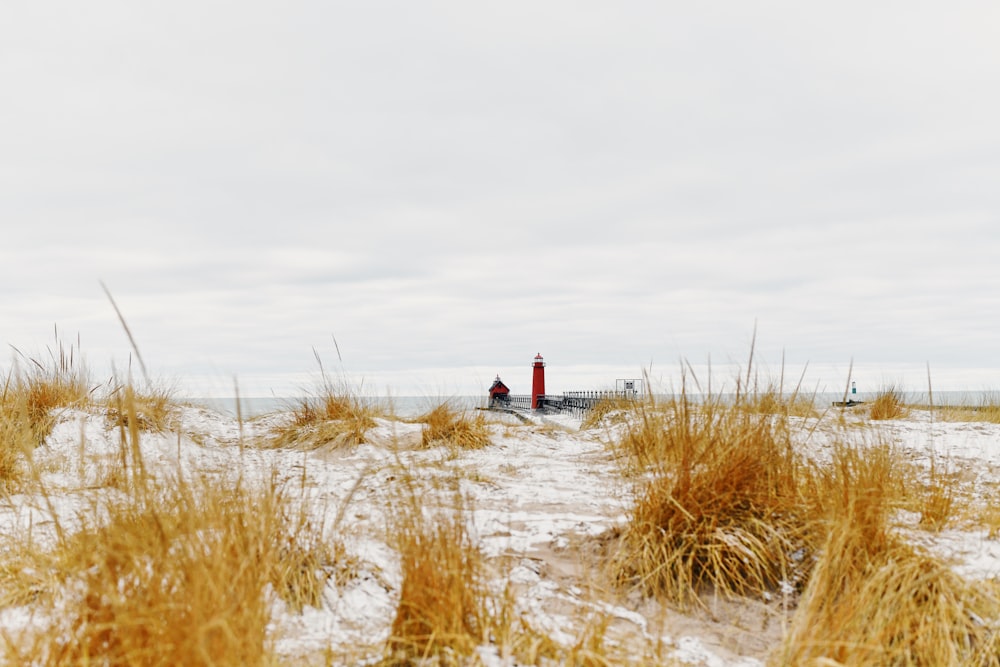 a red light house sitting on top of a snow covered field