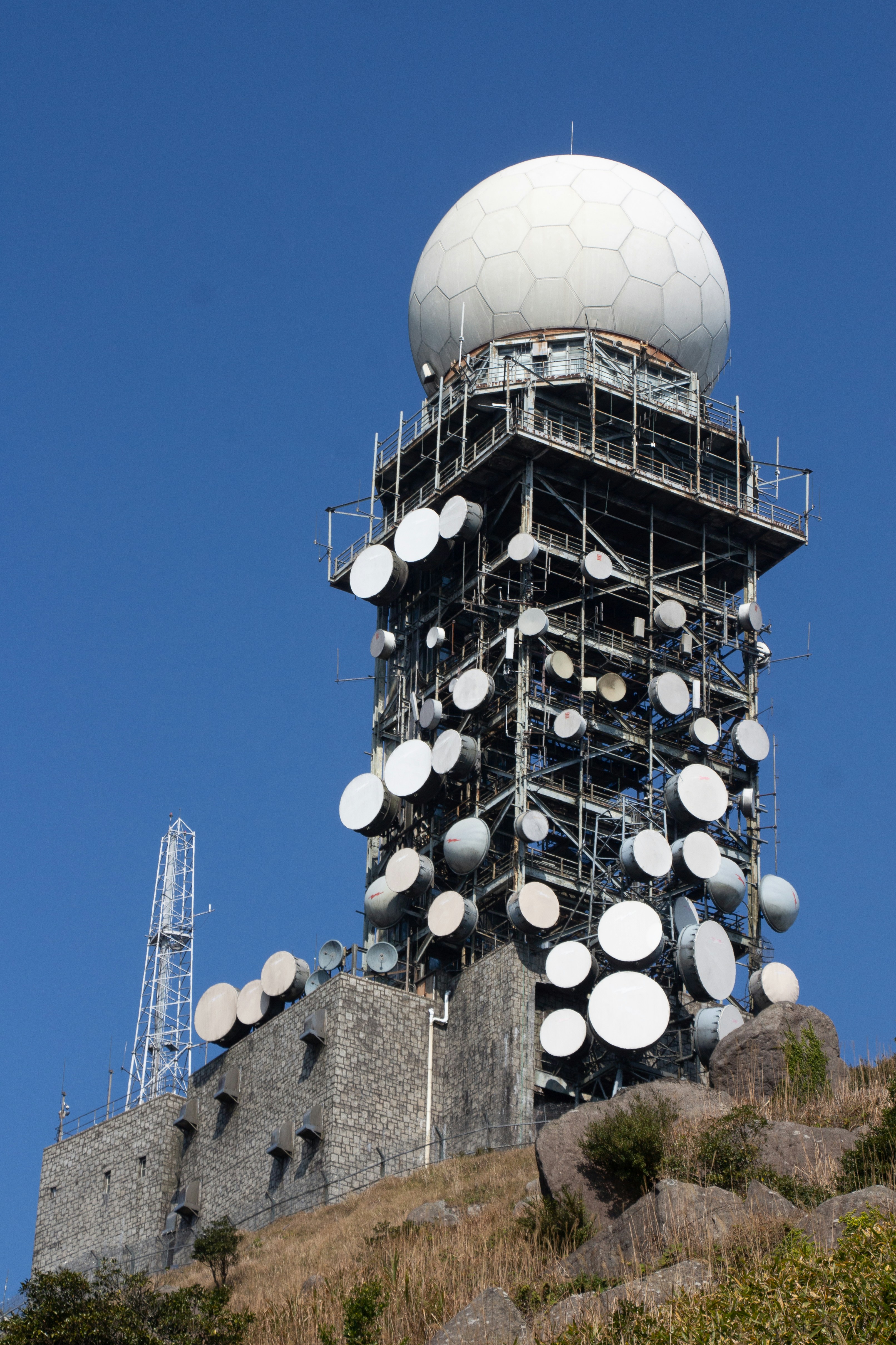 Advanced weather radar system with rotating dish against clear sky
