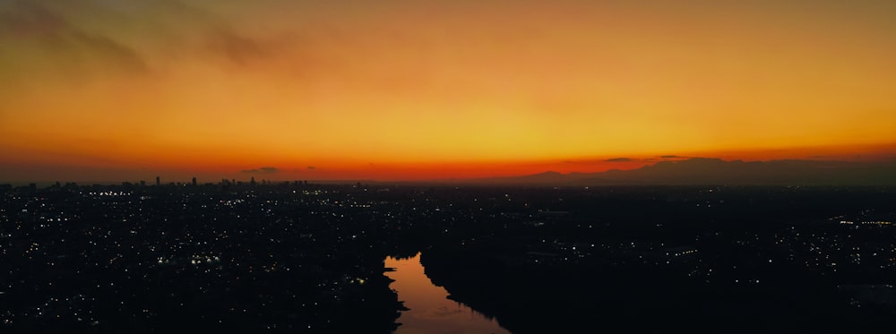 Le soleil se couche sur une ville et une rivière