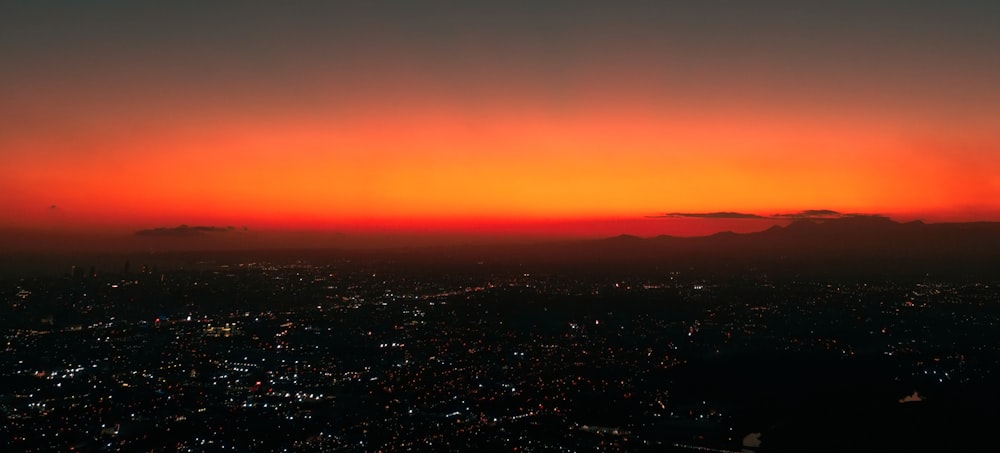 uma vista de uma cidade ao pôr do sol de um avião