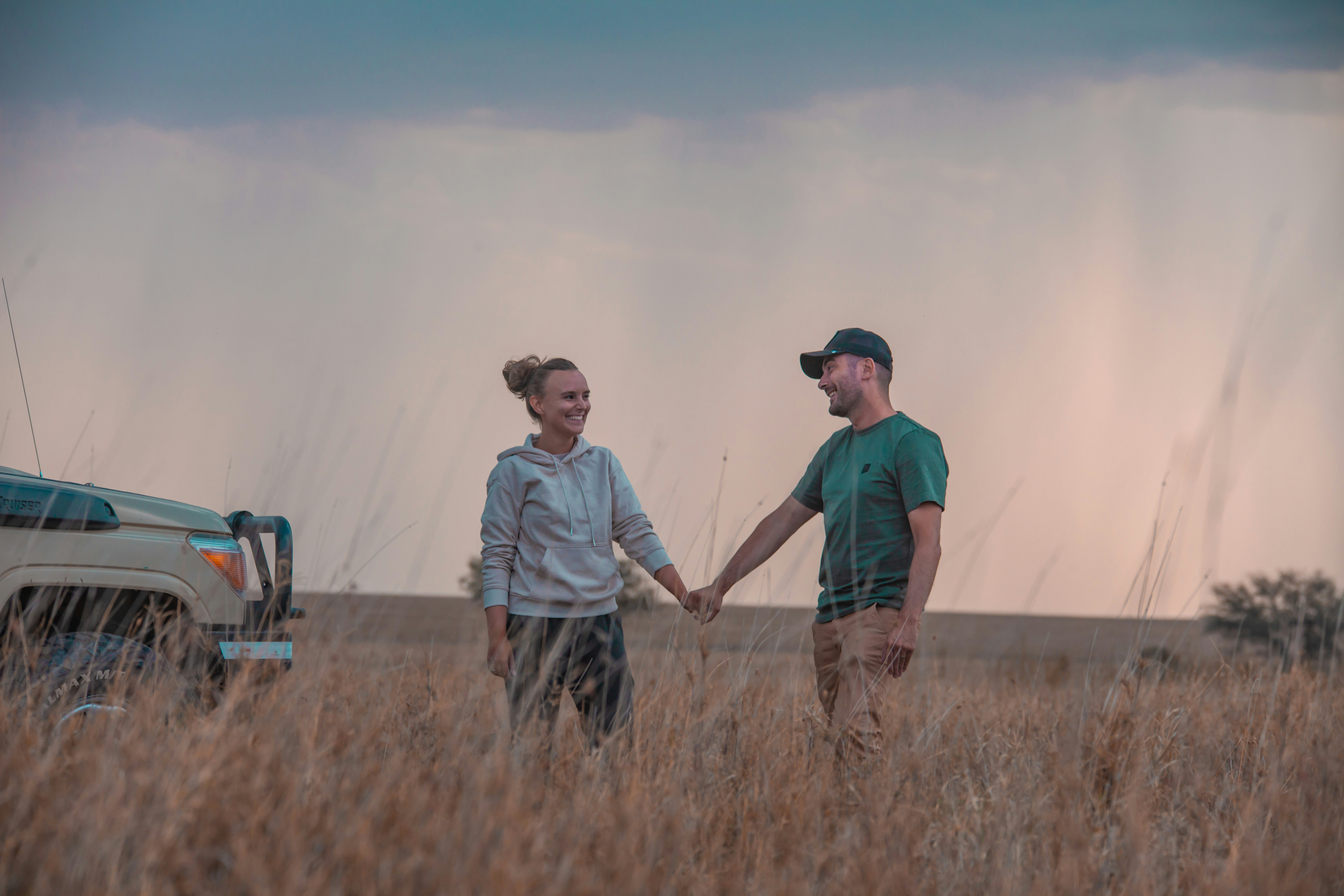 a man and a woman holding hands in a field