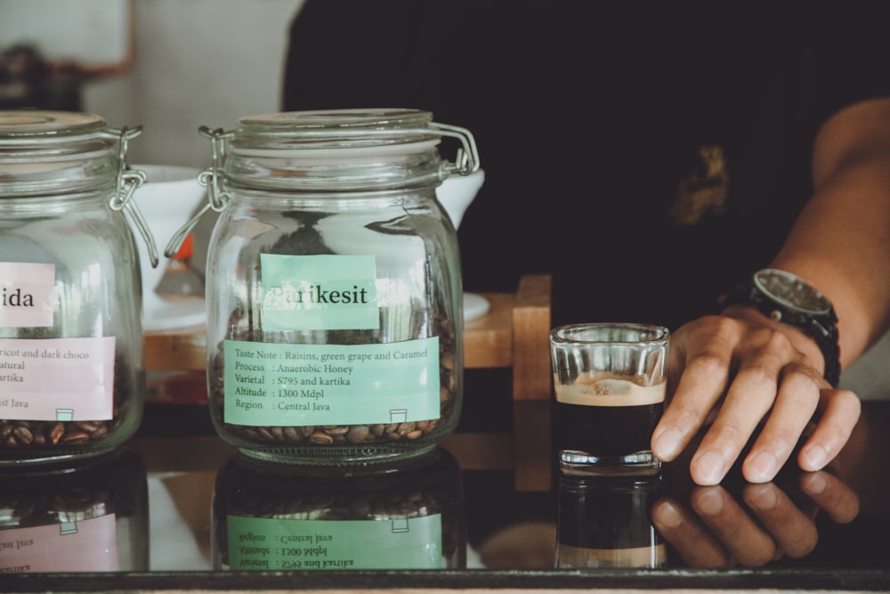 a person is holding a glass of coffee