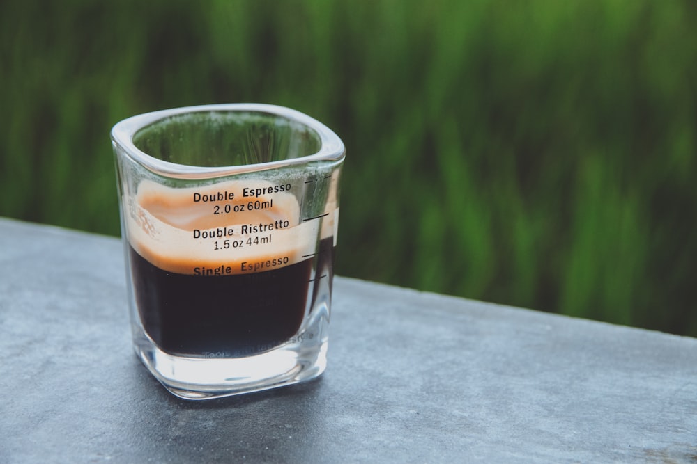 a shot glass filled with liquid sitting on a table