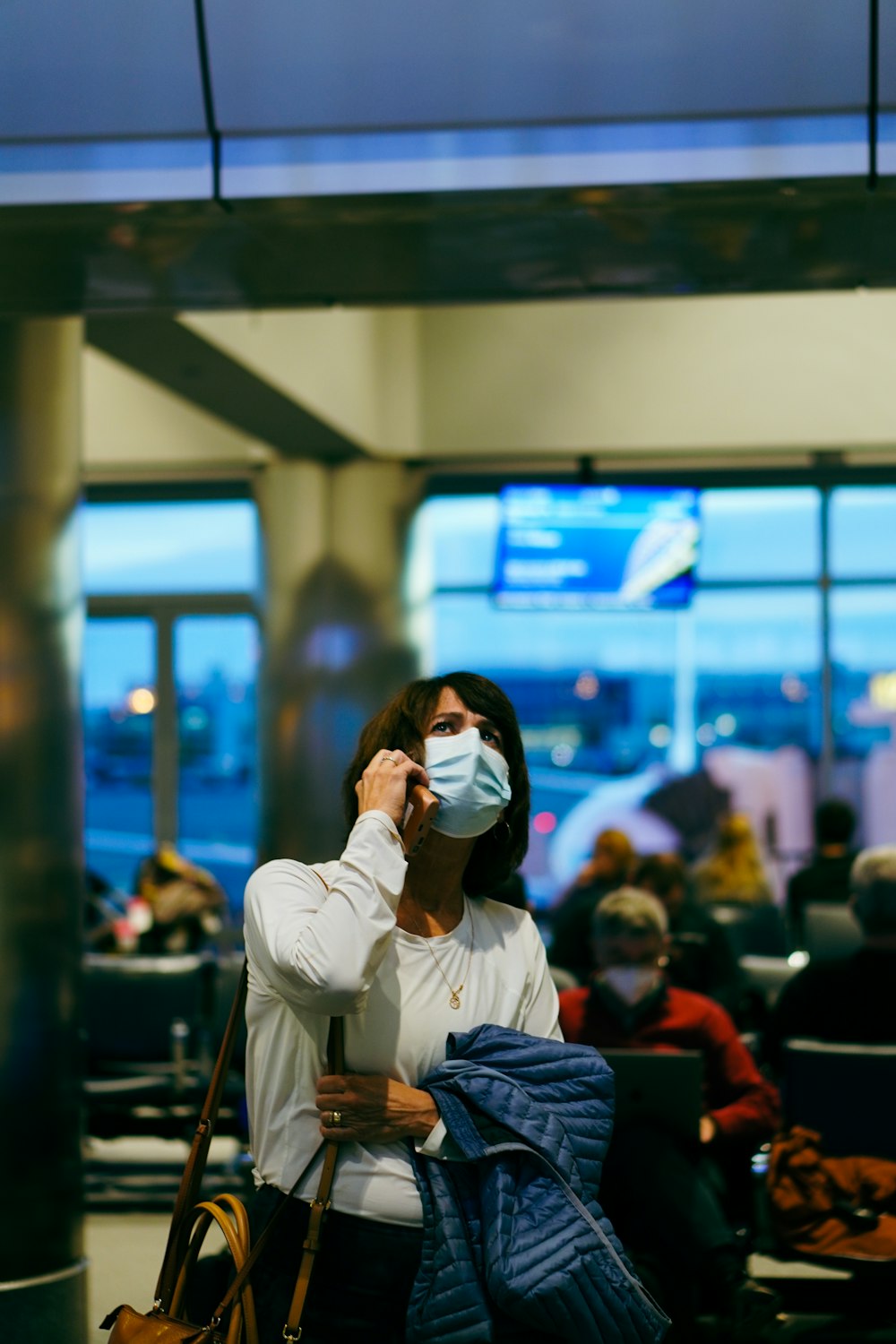 uma mulher usando uma máscara facial em um aeroporto