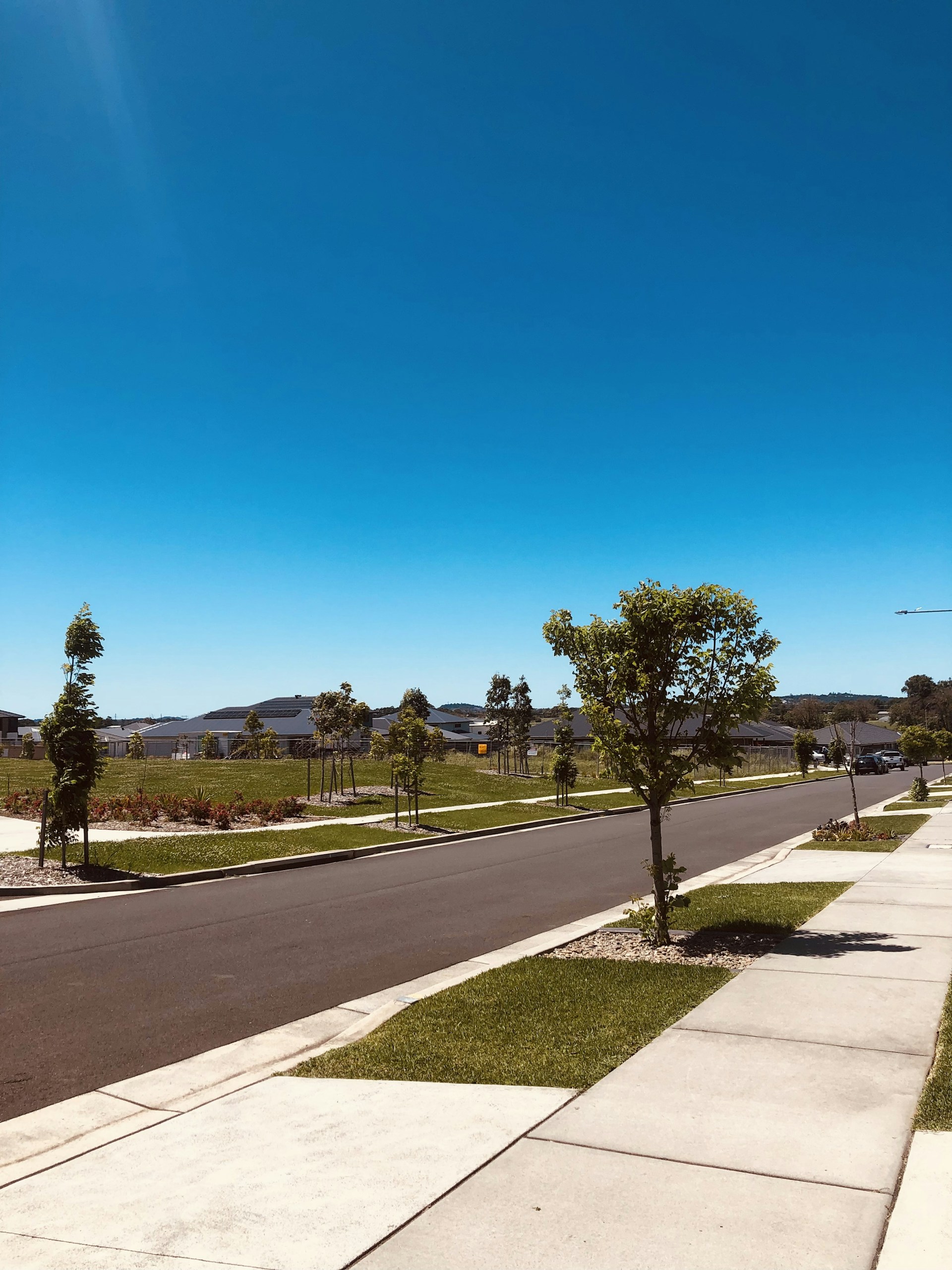 A brightly cleaned driveway glistening under the Austin sun, with freshly washed sidewalks lining a quiet neighborhood street.