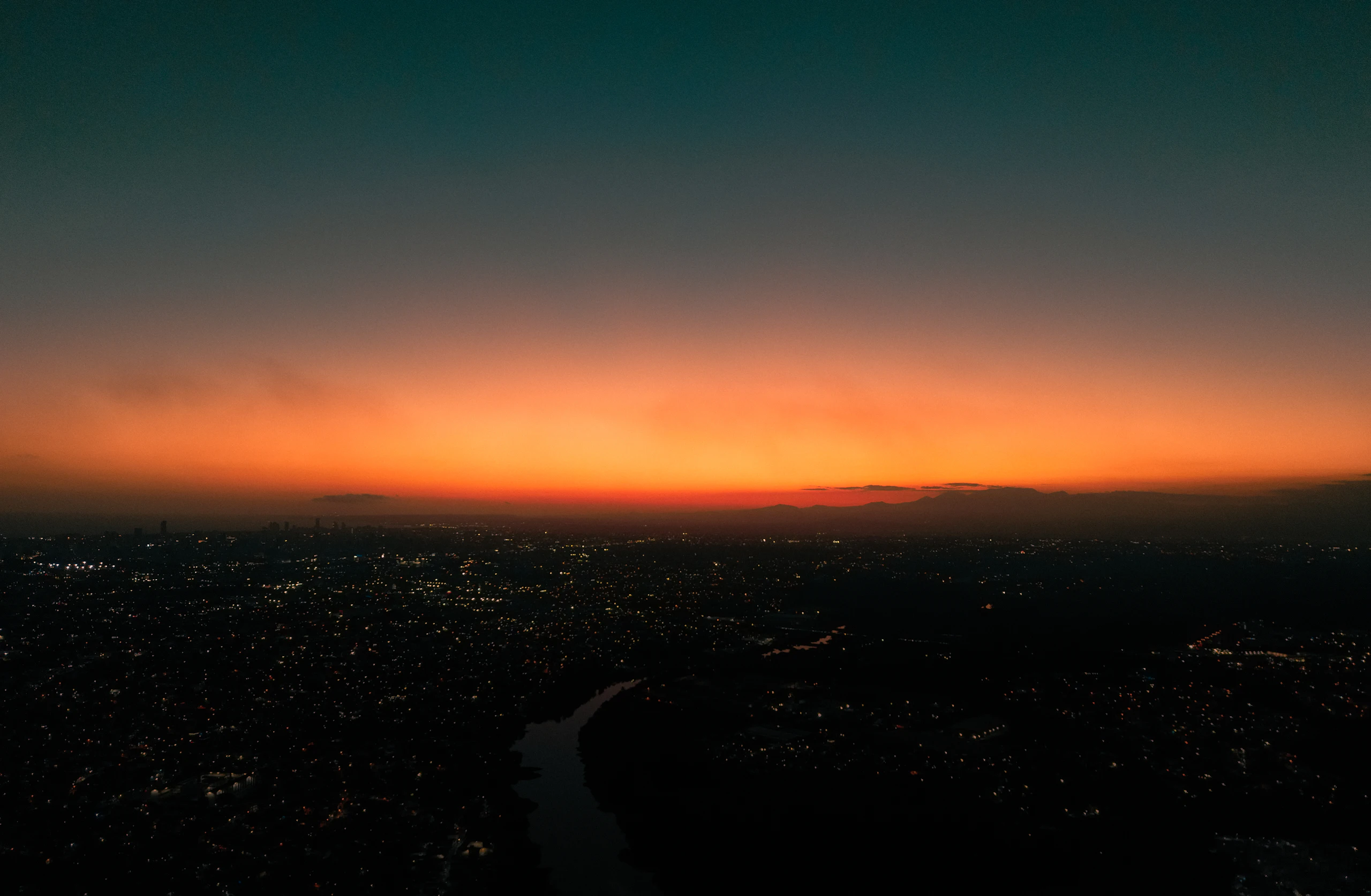 Horizonte ao crepúsculo sobre as luzes da cidade