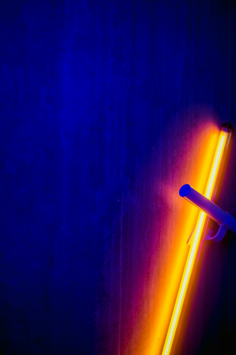 a neon tube is lit up against a dark background