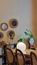 a room with a table, chairs, and a clock on the wall