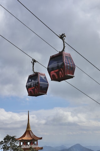 a couple of red and blue gondolas hanging from a wire