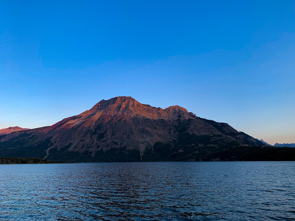 a large mountain rising above a body of water