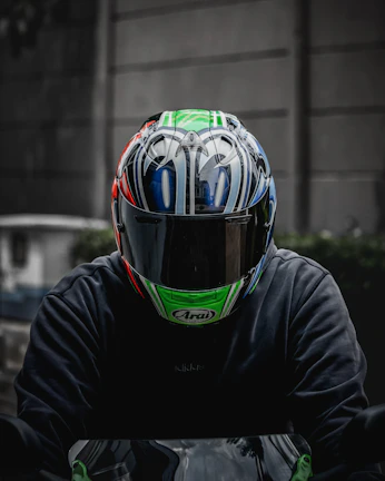Close-up of a motorcycle driver ready to start a ride, wearing a helmet with the Me Leva Aí logo in yellow ochre.