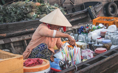 a woman sitting in a boat filled with lots of items