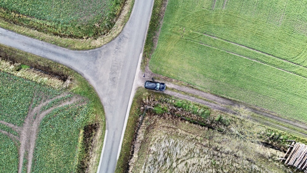 an aerial view of a car driving down a country road