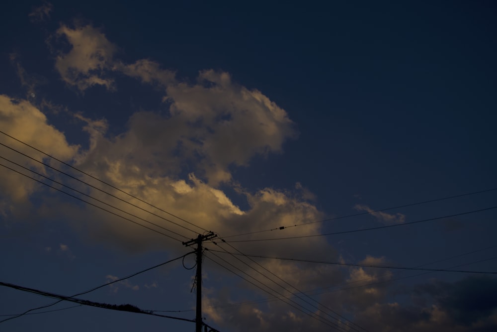 a dark sky with clouds and power lines