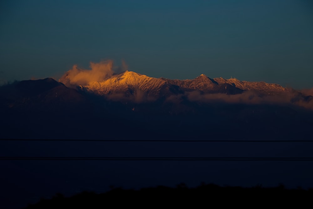 a view of a mountain range with clouds in the foreground