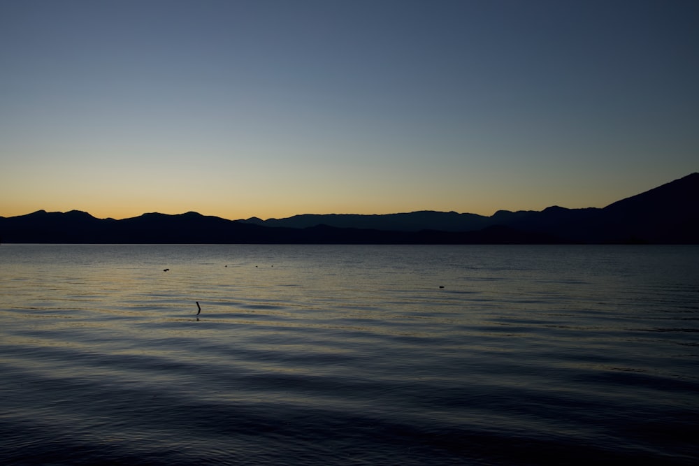 a body of water with mountains in the background