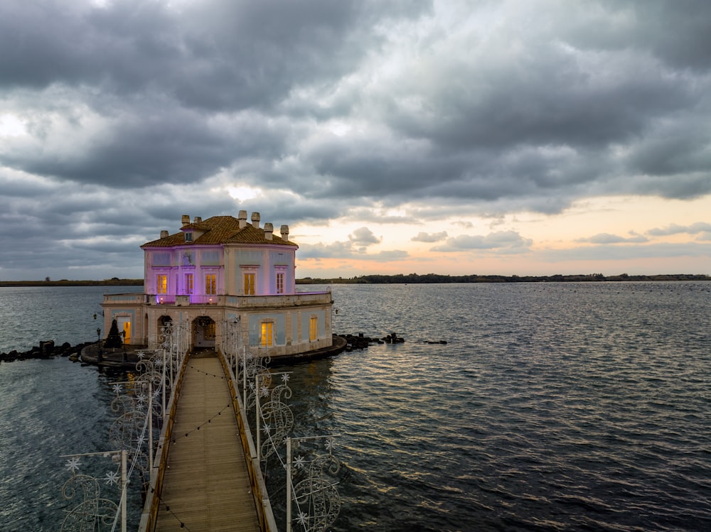 a house sitting on a dock in the middle of a lake