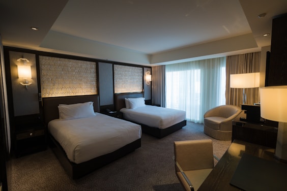 a hotel room with two beds and a chair