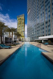The modern outdoor pool sparkling under the afternoon sun with lounge chairs nearby.