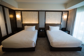 a hotel room with two beds and a window