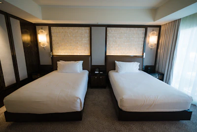 a hotel room with two beds and a window