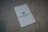 A white card with the Waldorf Astoria Las Vegas logo is placed on a textured, woven surface.