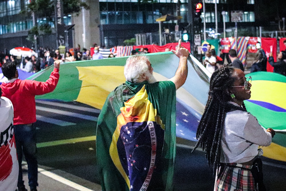 a group of people walking down a street holding flags