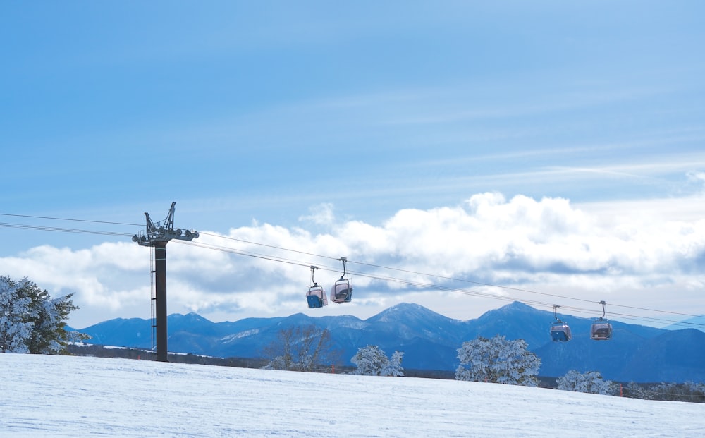 a ski lift going over a snow covered slope