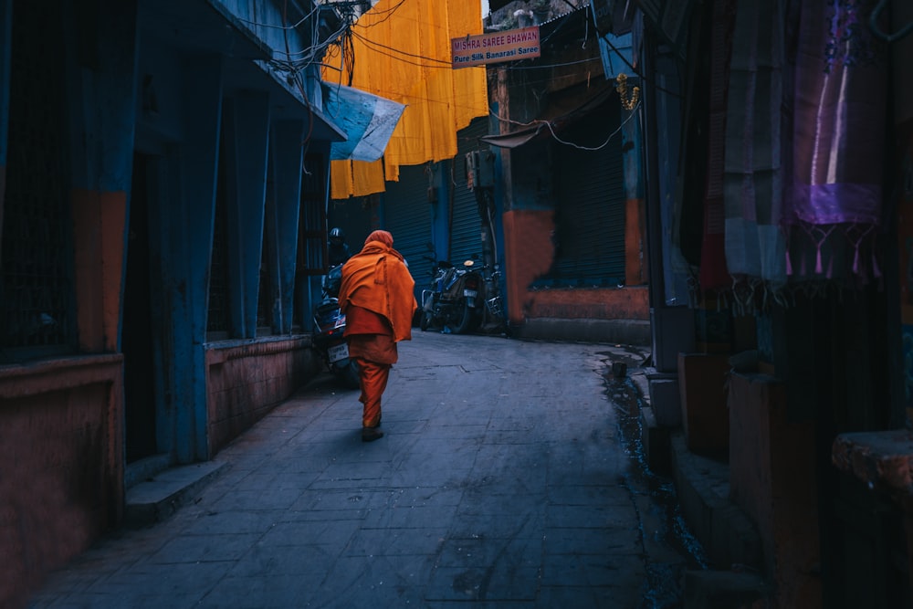 a person in an orange outfit walking down a street