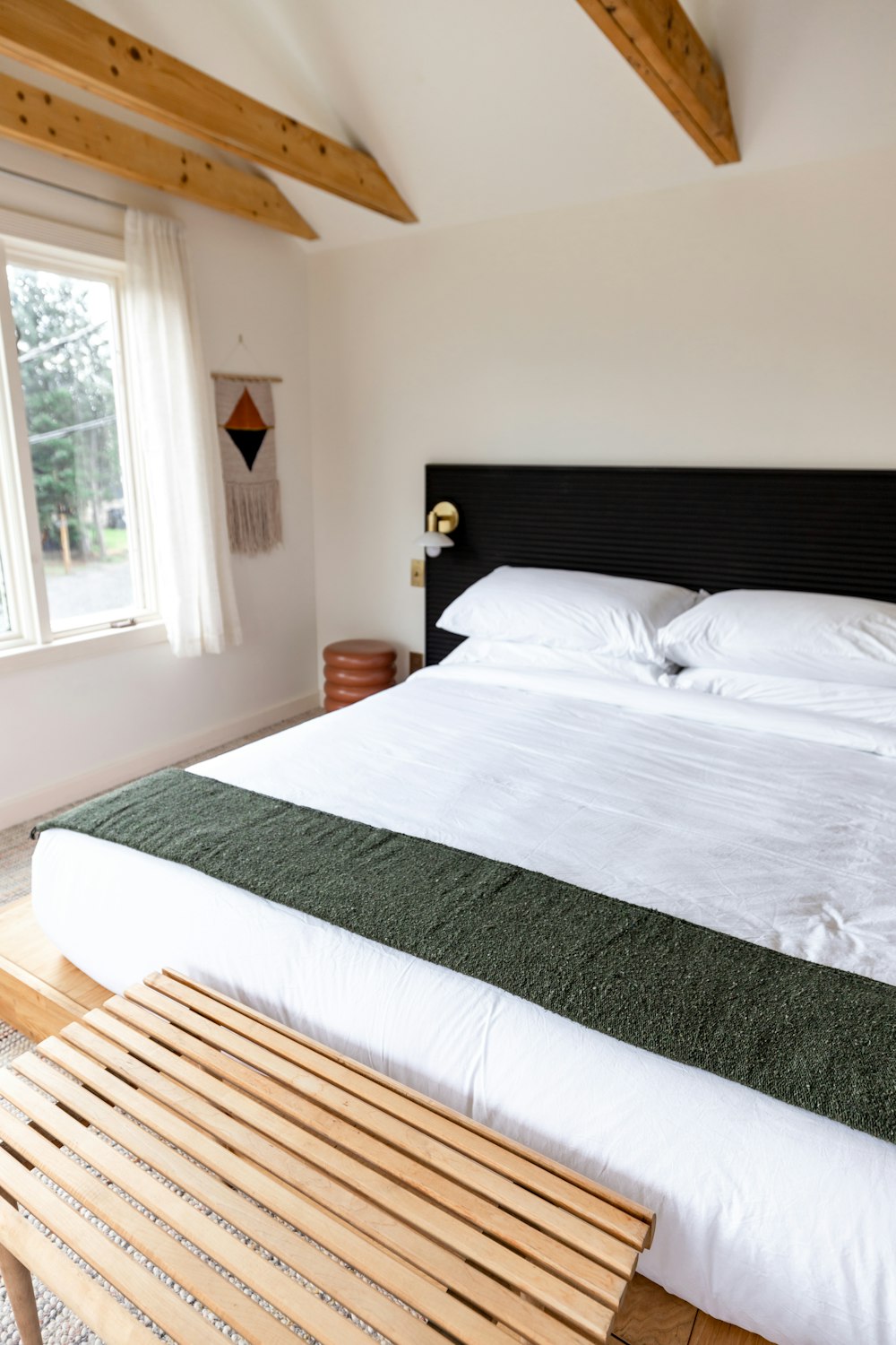 a bedroom with a large bed and a wooden bench