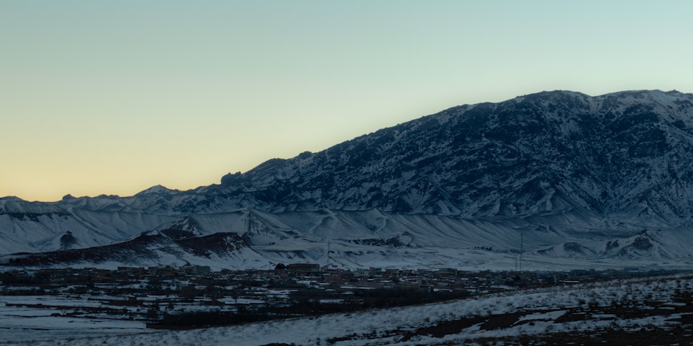 a snow covered mountain with a town below it