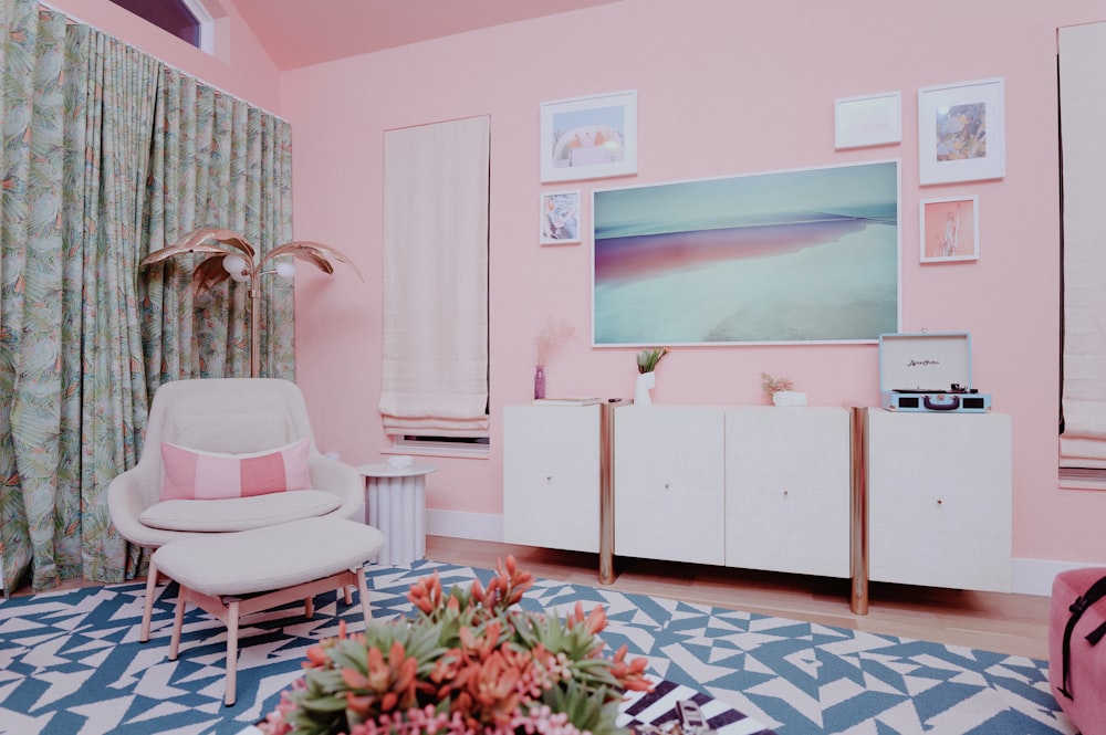 a living room with pink walls and a white chair