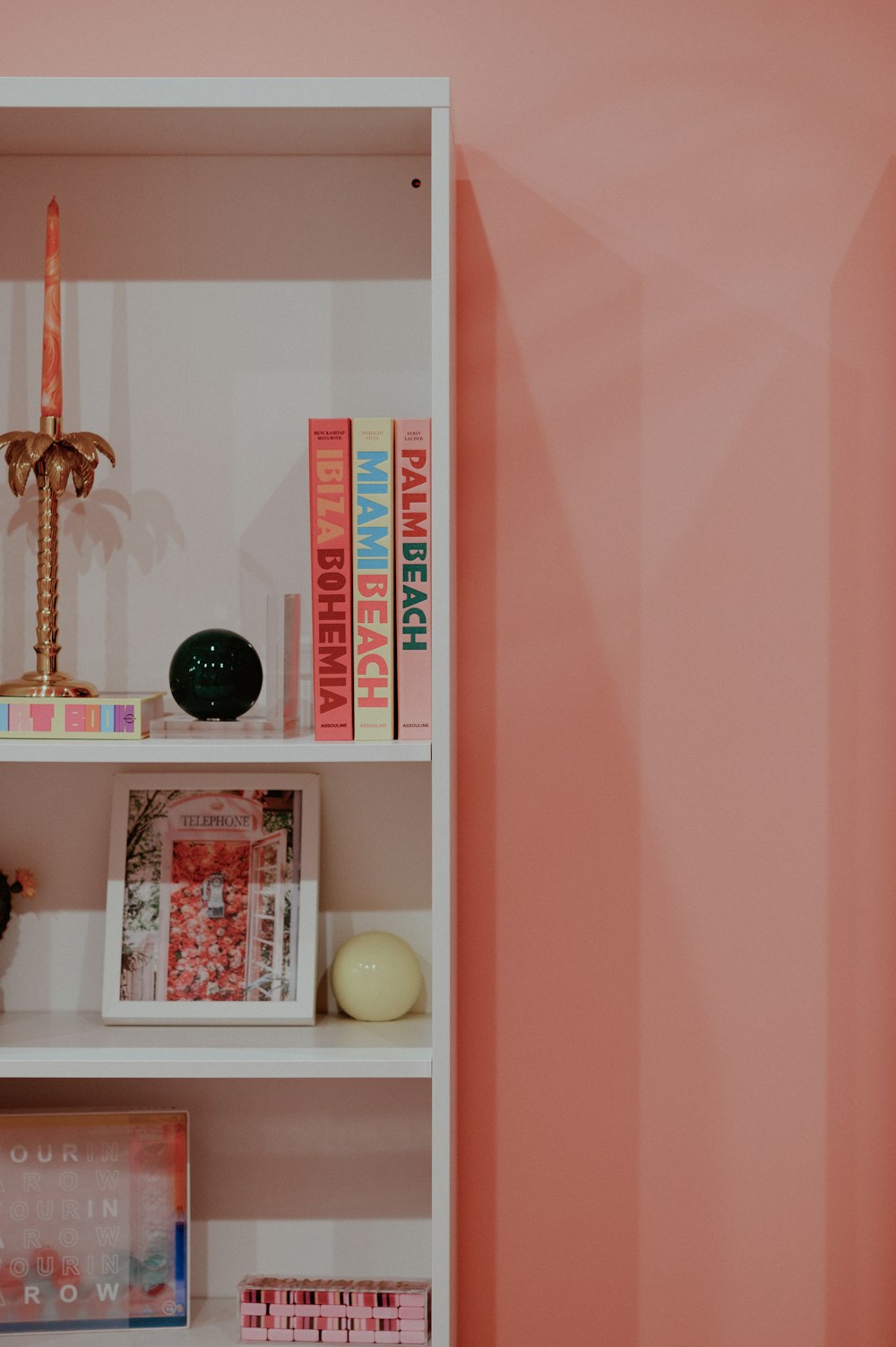 a shelf with books and a candle on top of it