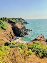 A picturesque coastal view with adventure-seekers exploring the shoreline.
